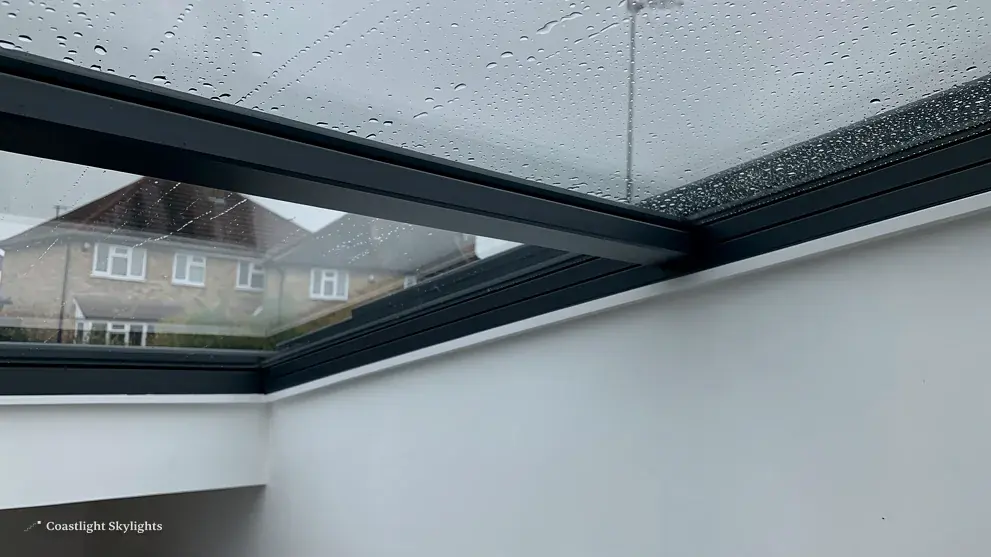 Glass rooflight seen from below with rooftops visible beyond