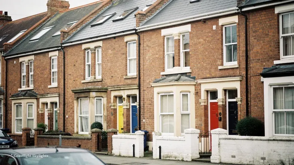 Street of brick terraced houses with roof windows set into the pitched roofs