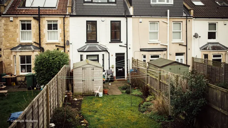 Rear of terraced houses with long back gardens and pitched roofs