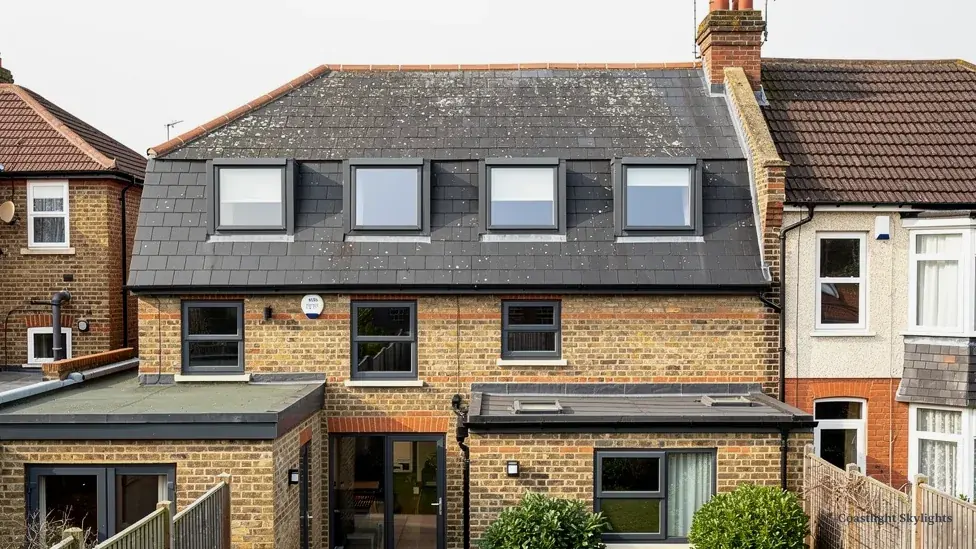 Rear of a brick terrace with dormers and a flat roof extension