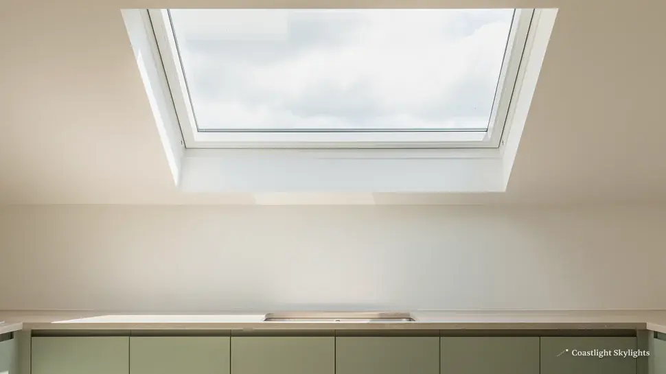 Looking up at a flat rooflight in the ceiling of an empty white room