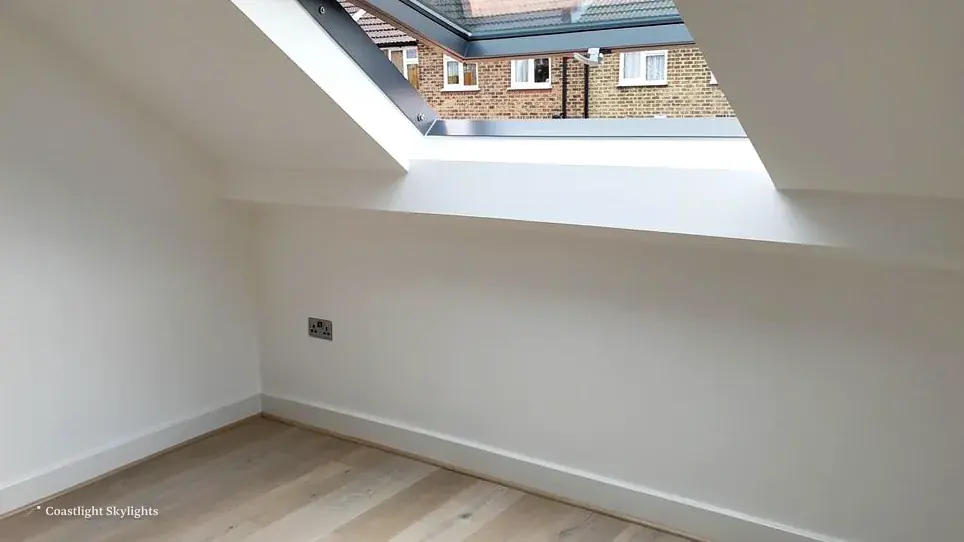 Empty white loft room with a roof window in the sloping ceiling