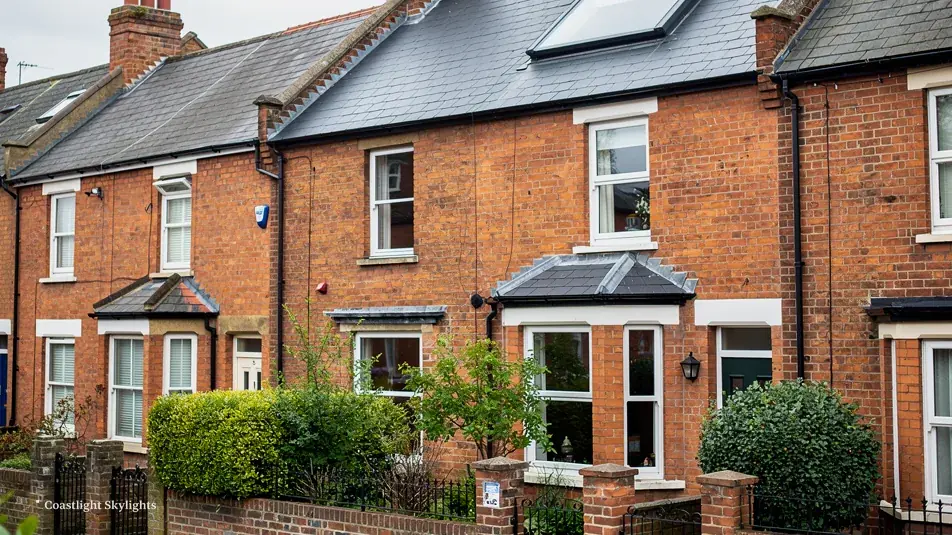 Row of red brick terraced houses with bay windows and tiled roofs