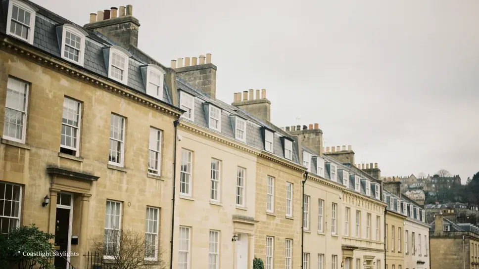 Row of tall Georgian stone terraced houses with pitched roofs