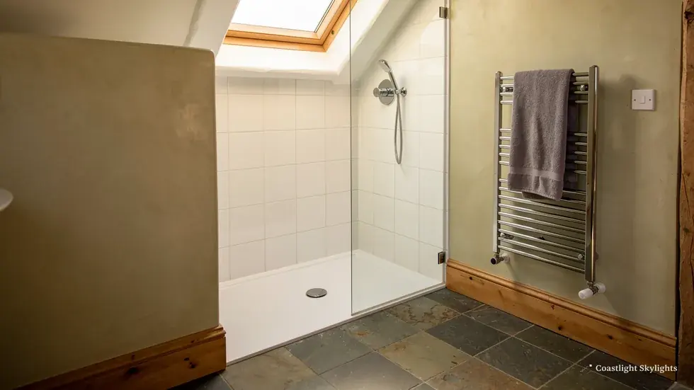 Shower room with a chrome towel rail and a slate floor