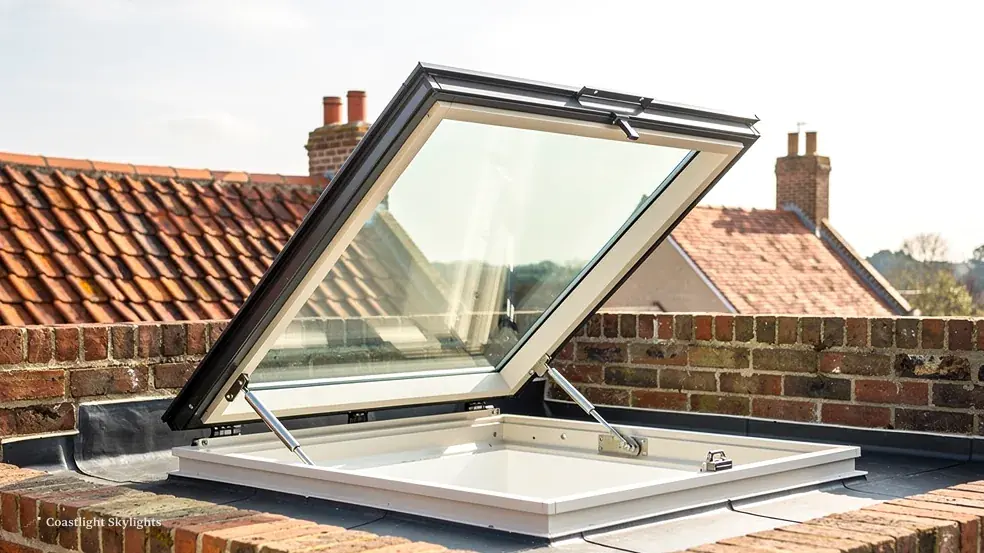 Opening glass rooflight raised on a flat roof beside red clay tiles