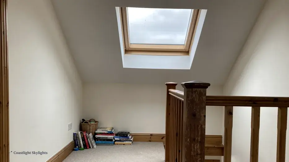 Landing with a timber balustrade and a roof window high in the sloping ceiling