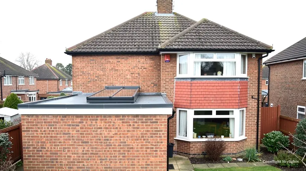 Brick house with a flat roofed bay extension below the front windows