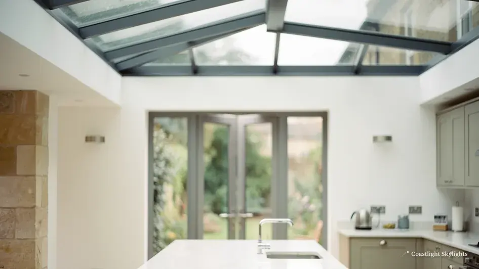 Glazed roof lantern above a bright white room with glazed doors to the garden