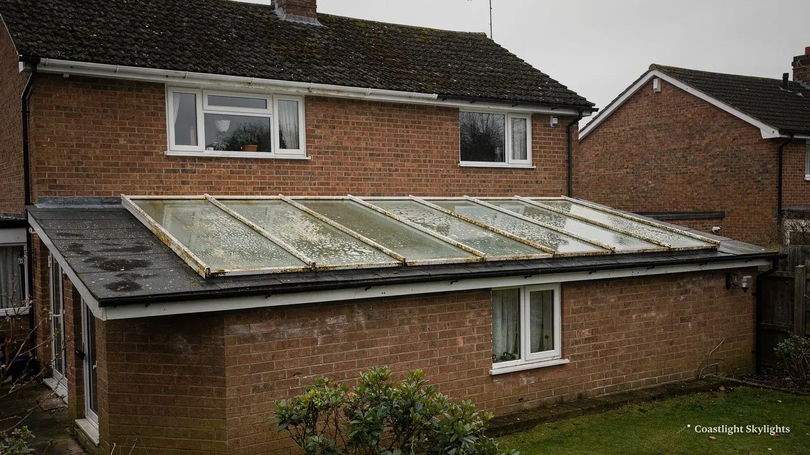 Long glass roof lantern on a low roof at the back of a brick house
