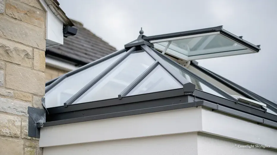 Corner of a glass roof lantern against a rendered and stone wall