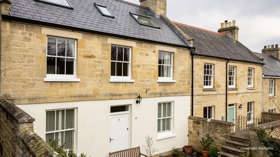 Row of stone terraced cottages with gardens and pitched slate roofs