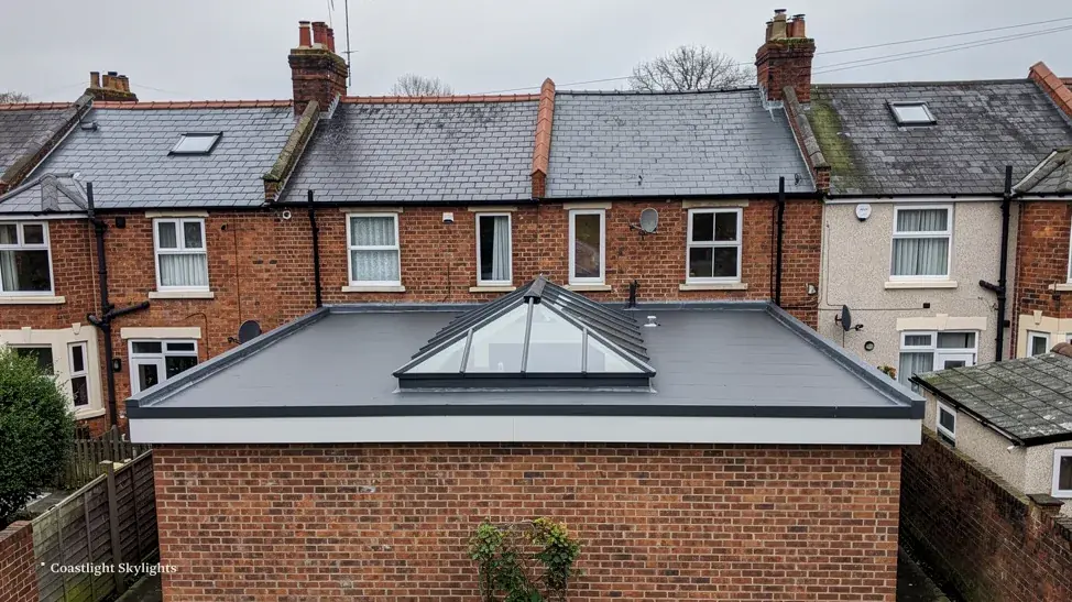 Glass pyramid roof lantern on a flat roof above a red brick terraced house