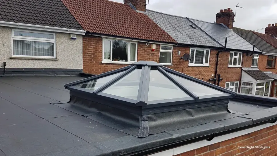Glass pyramid roof lantern on a flat roof above a terraced house extension